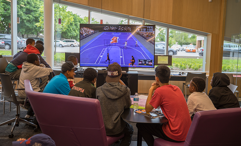 A group of teens playing a video game at the library